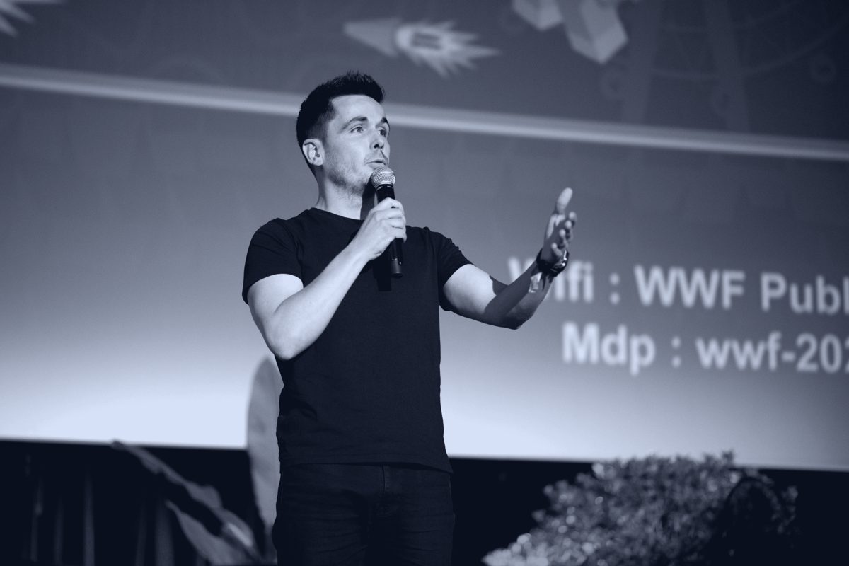 Cyril de Sousa Cardoso en conférence, micro à la main, en 2023
